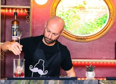 a men bartender pouring a cocktail